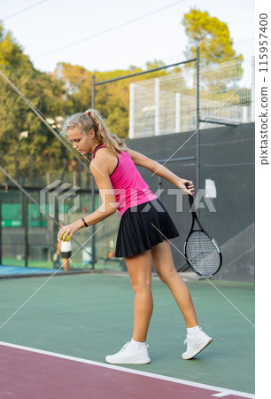 Tennis game - girl getting ready to hit the ball with racket Tennis game - girl getting ready to hit the ball with racket 115957400
