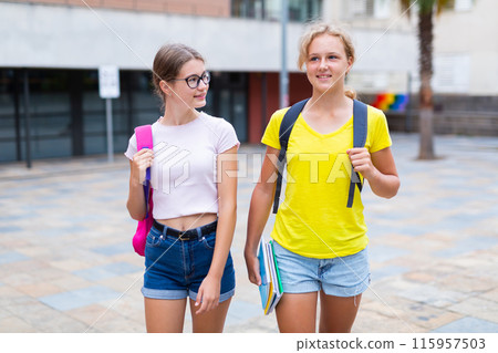 Portrait of two female students walking down street to college 115957503