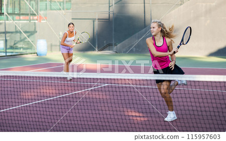 Portrait of sporty young woman in activewear playing tennis on court, ready to hit ball. Active lifestyle concept 115957603