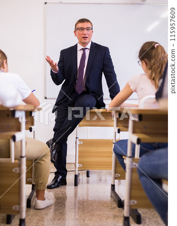 Male teacher lecturing to students at classroom 115957609