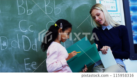In school, Caucasian teacher is showing a folder to a biracial student 115958316