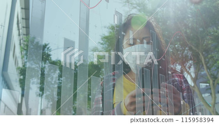 Asian business analyst wearing mask and looking at graphs on glass 115958394