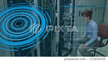 Caucasian woman sitting near server rack, looking at tablet 115958430