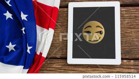 A tablet displaying winking emoji rests beside American flag A tablet displaying winking emoji rests beside American flag 115958514