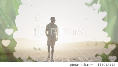 A young African American male standing on beach at sunset A young African American male standing on beach at sunset 115958558