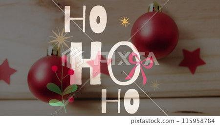 Two red Christmas ornaments hang in front of festive backdrop with HO HO HO text Two red Christmas ornaments hang in front of festive backdrop with HO HO HO text 115958784