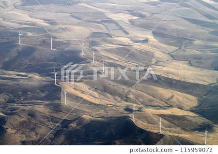 Windmill wind turbines near etna volcano in sicily and farmed fields aerial view from airplane 115959072