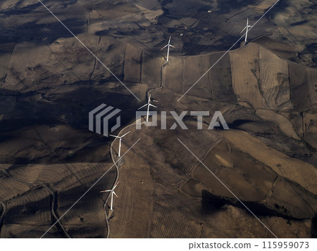 Windmill wind turbines near etna volcano in sicily and farmed fields aerial view from airplane 115959073