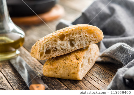 Italian ciabatta bread on wooden table. 115959400