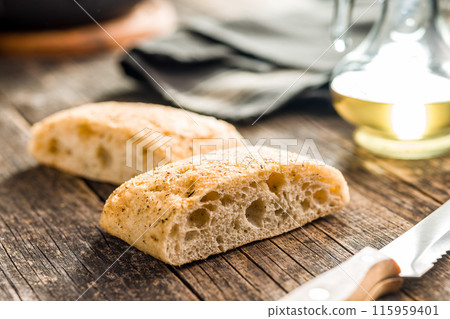 Italian ciabatta bread on wooden table. 115959401