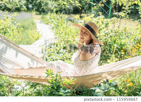 Young woman relaxing in a hammock  115959887