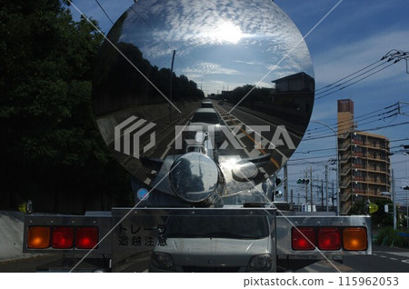 Sky and clouds reflected in the silver mirror of a milk tanker truck driving through the city 1 Sky and clouds reflected in the silver mirror of a milk tanker truck driving through the city 1 115962053
