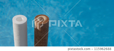 Two water filter cartridges, one clean and one dirty, against a swimming pool backdrop. Wide shot 115962688