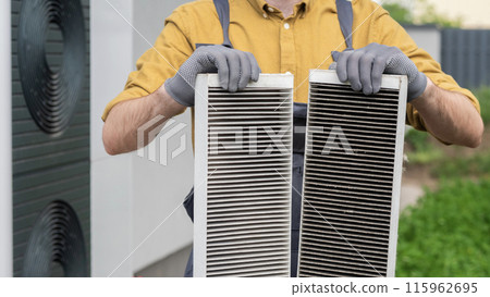 Plumber with gloves showing two heavily clogged air filters from a home air conditioning system. Plumber with gloves showing two heavily clogged air filters from a home air conditioning system. 115962695