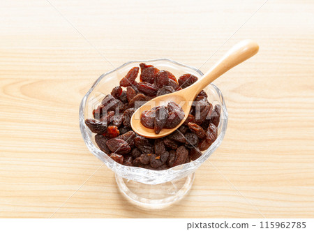 Raisins in a glass bowl (with spoon) 115962785