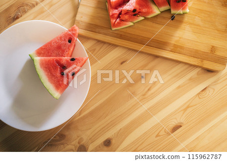 Triangular pieces of watermelon on a wooden cutting board 115962787