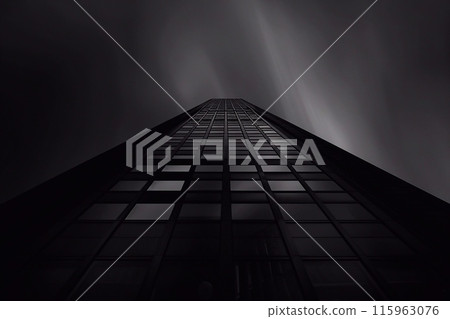 Looking up at a tall skyscraper in a foggy night. 115963076
