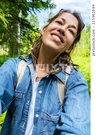 Hiker woman taking selfie in summery forest. Hiker woman taking selfie in summery forest. 115963694