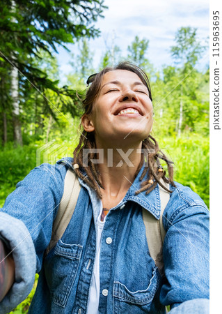 Hiker woman taking selfie in summery forest. Hiker woman taking selfie in summery forest. 115963695