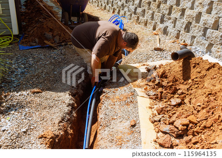 Plumbing technicians isolate water pvc pipes with thermal insulation before installing them 115964135