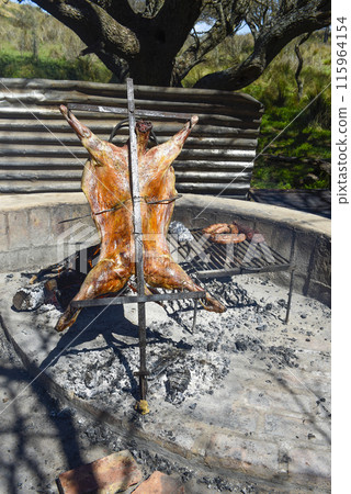 Lamb on the spit, cooked with the traditional Argentine method, La Pampa province, Patagonia, Argentina. Lamb on the spit, cooked with the traditional Argentine method, La Pampa province, Patagonia, Argentina. 115964154