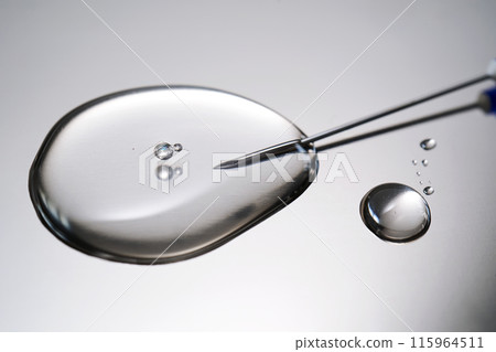 A drop of medicine flowing from a syringe with a needle. A drop of medicine flowing from a syringe with a needle. 115964511