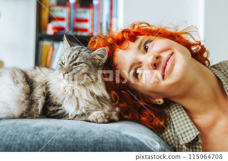 portrait red-haired attractive young woman with fluffy big cat 115964708