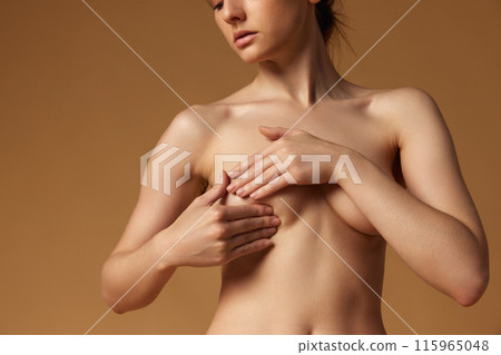 Close up photo of young woman covered her breast against sandy studio background. Female health prevention 115965048