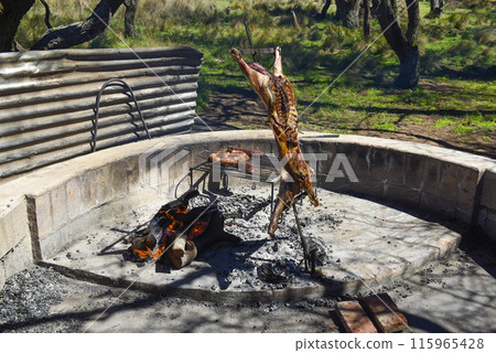 Lamb on the spit, cooked with the traditional Argentine method, La Pampa province, Patagonia, Argentina. Lamb on the spit, cooked with the traditional Argentine method, La Pampa province, Patagonia, Argentina. 115965428