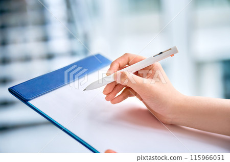 填寫剪貼簿的年輕女子的手 填寫剪貼簿的年輕女子的手 115966051