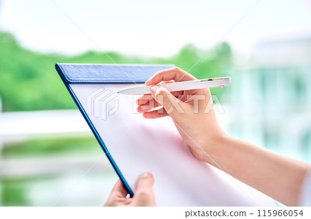 填寫剪貼簿的年輕女子的手 填寫剪貼簿的年輕女子的手 115966054