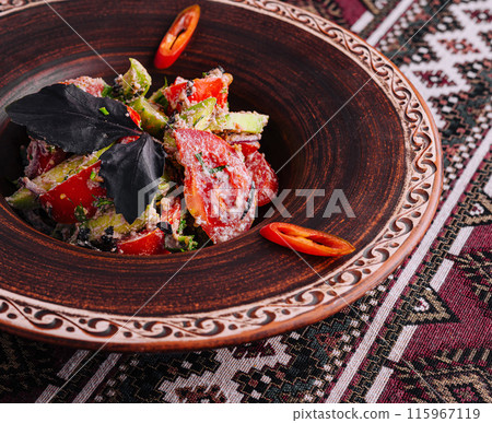 Traditional spicy tomato salad on ethnic pattern tablecloth 115967119