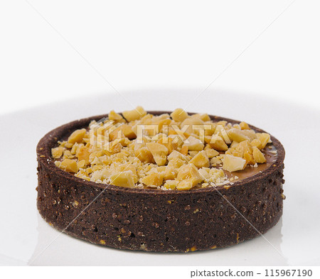 Chocolate tart with nut topping on white plate 115967190