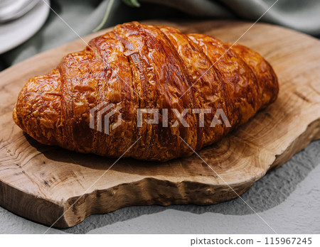 close up Fresh croissant on rustic table close up Fresh croissant on rustic table 115967245