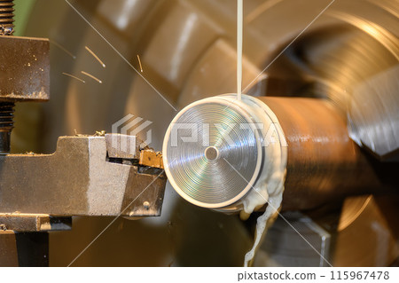 The lathe machine finish cut  metal shaft parts with liquid coolant method. 115967478