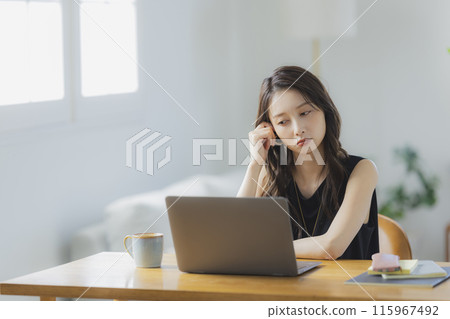 一位年輕女子在客廳在家工作 一位年輕女子在客廳在家工作 115967492