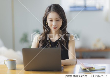 一位年輕女子在客廳在家工作 一位年輕女子在客廳在家工作 115967493