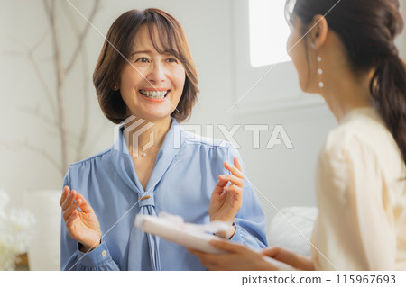 Two women having a conversation in a cafe 115967693