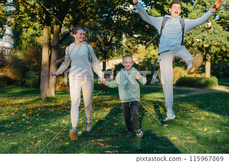 a family mom and 2 sons are having fun, running in the park and jumping. Sons, children, mom, run, play, rejoice, enjoy nature in summer. Family teamwork. Happy family team, running together in field 115967869
