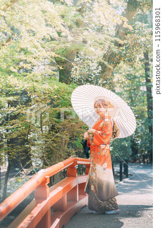 New adults wearing furisode kimonos walking through the temple grounds 115968301