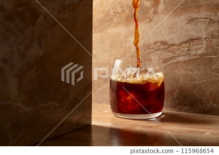 Black iced coffee on a ceramic table. 115968654