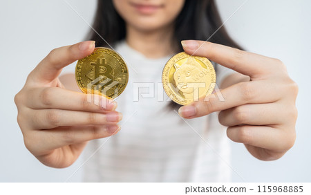 Woman holding Bitcoin and Dogecoin tokens. Woman holding Bitcoin and Dogecoin tokens. 115968885