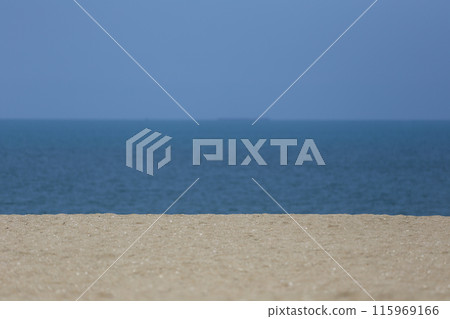 A beach with lots of sand and a backdrop of blue sky and sea. A beach with lots of sand and a backdrop of blue sky and sea. 115969166