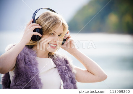 Happy woman wearing headphones outdoor Happy woman wearing headphones outdoor 115969260