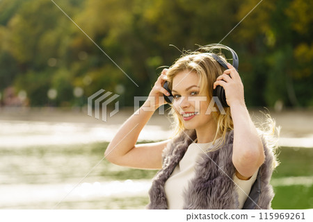 Happy woman wearing headphones outdoor Happy woman wearing headphones outdoor 115969261