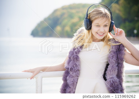Happy woman wearing headphones outdoor Happy woman wearing headphones outdoor 115969262