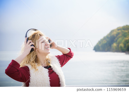 Happy woman wearing headphones outdoor Happy woman wearing headphones outdoor 115969659