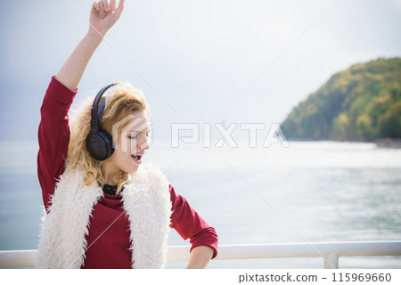 Happy woman wearing headphones outdoor Happy woman wearing headphones outdoor 115969660