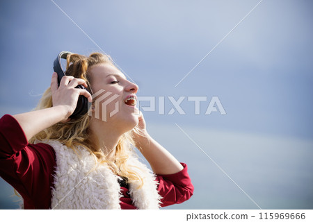 Happy woman wearing headphones outdoor Happy woman wearing headphones outdoor 115969666