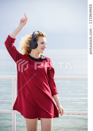 Woman wearing headphones outdoor 115969668